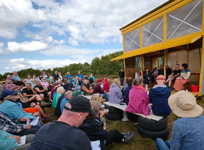 Large outdoor audience attending a panel discussion at the Bog Bothy