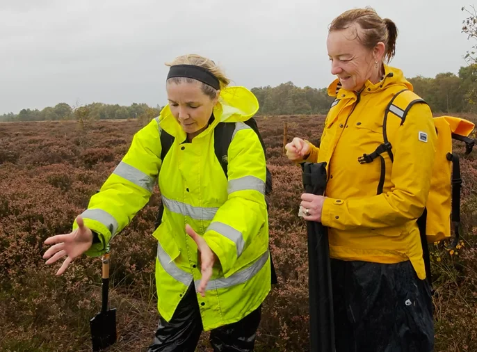 Two archaeologists discussing the shape of an archaeological object on Cornafulla Bog